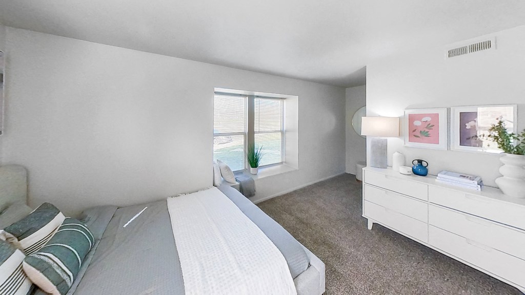 a bedroom with a bed and a dresser and a window