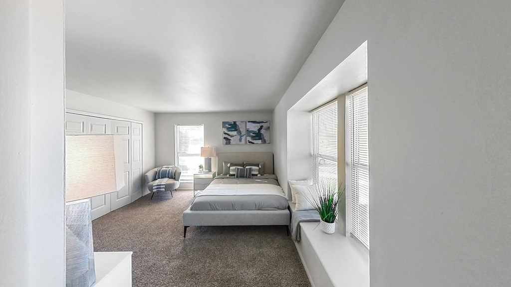 a bedroom with a bed and a large window