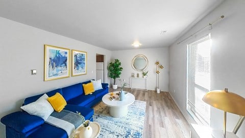a living room with a blue couch and a round table