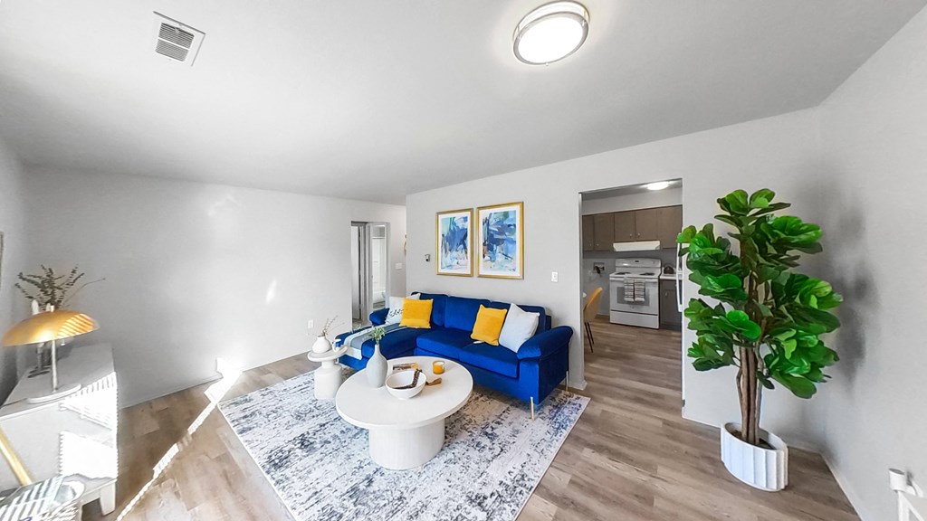a living room with a blue couch and a white table