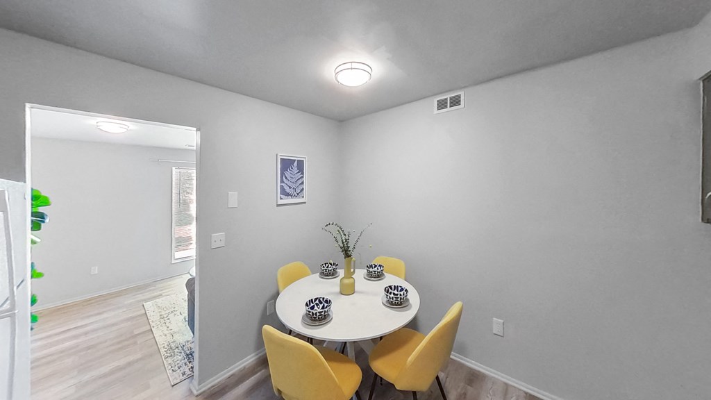 a dining room with a white table and yellow chairs