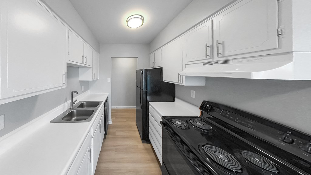 a kitchen with white cabinets and black appliances and a sink