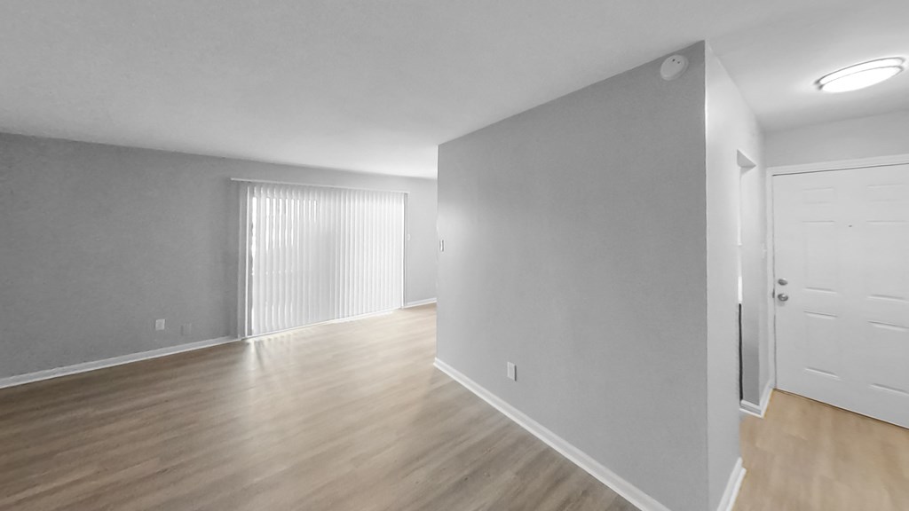 an empty living room with white walls and wood flooring
