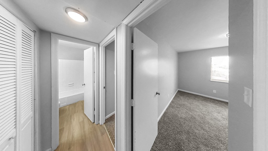 the living room of a renovated house with white walls and wood floors