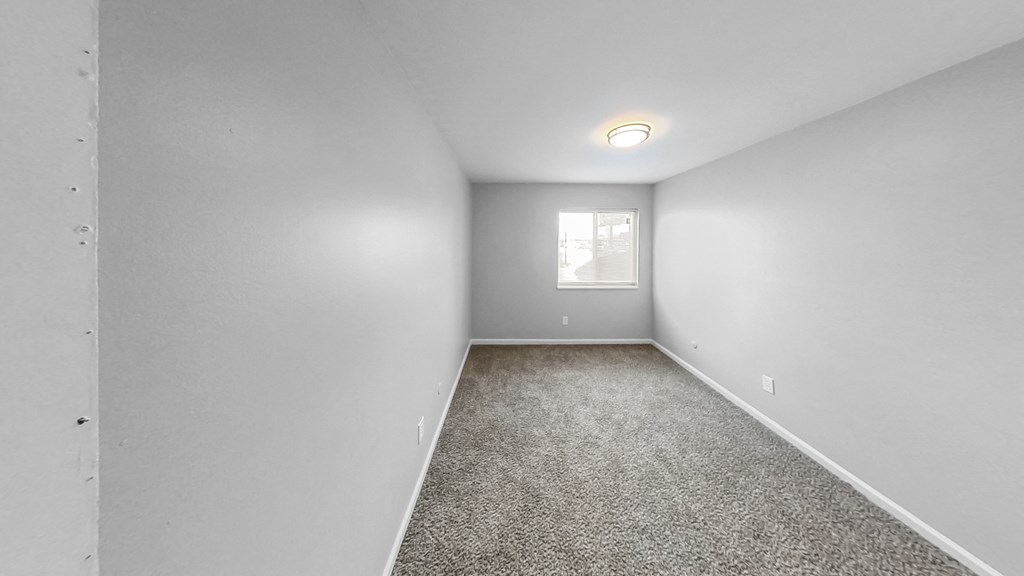 an empty room with carpet and a window