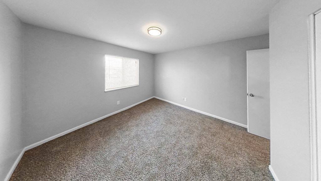 an empty room with carpet and a window