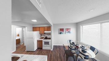 the living room and dining room of an apartment with a table and chairs