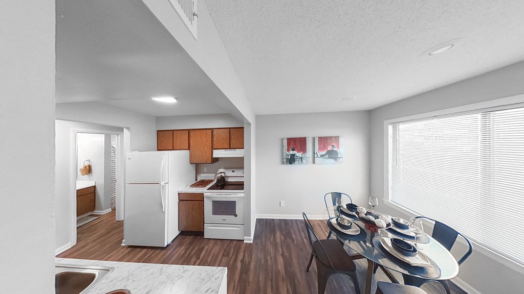 the living room and dining room of an apartment with a table and chairs