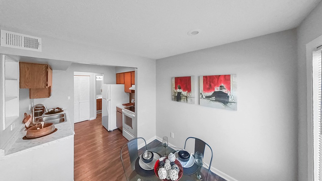 a kitchen and dining room with a glass table and chairs