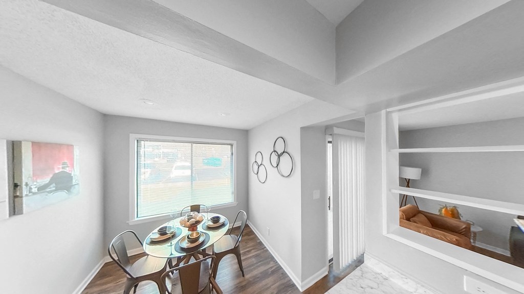 a dining room with a table and chairs and a window