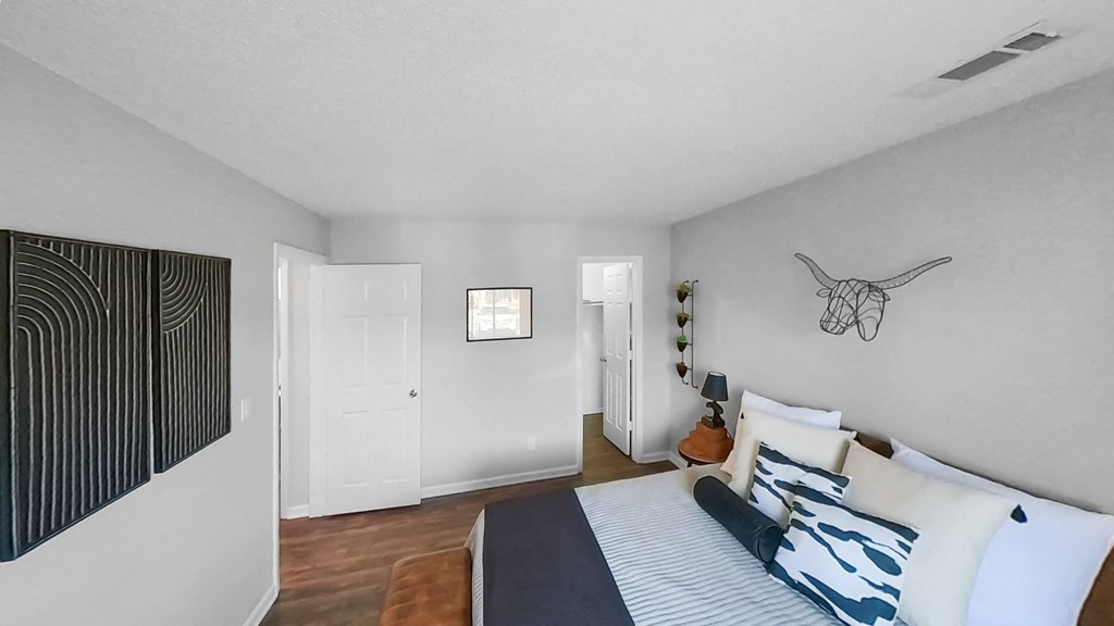 a bedroom with a bed and a door to a closet