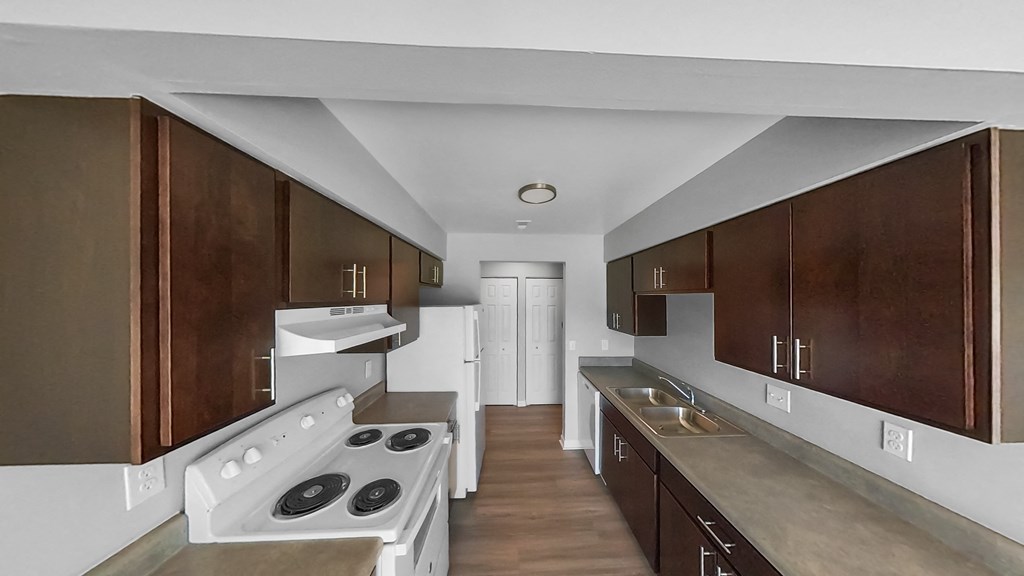 a kitchen with wooden cabinets and white appliances and a white stove