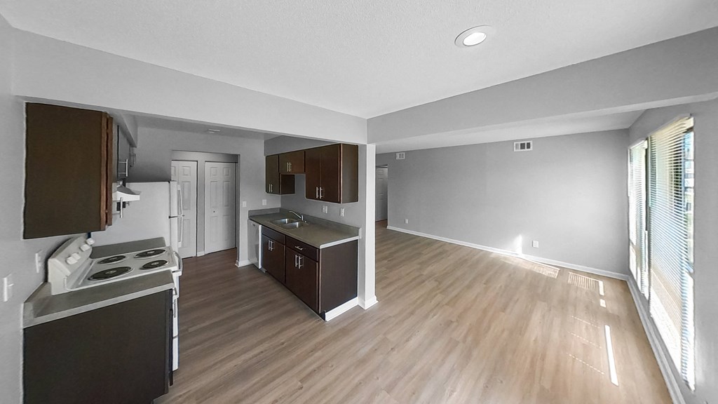 an empty kitchen and living room with wood flooring and