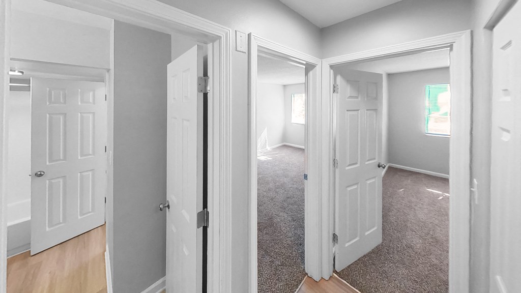 an empty room with white doors and a carpeted floor