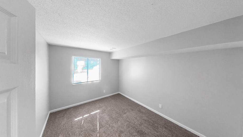 an empty room with carpet and a window