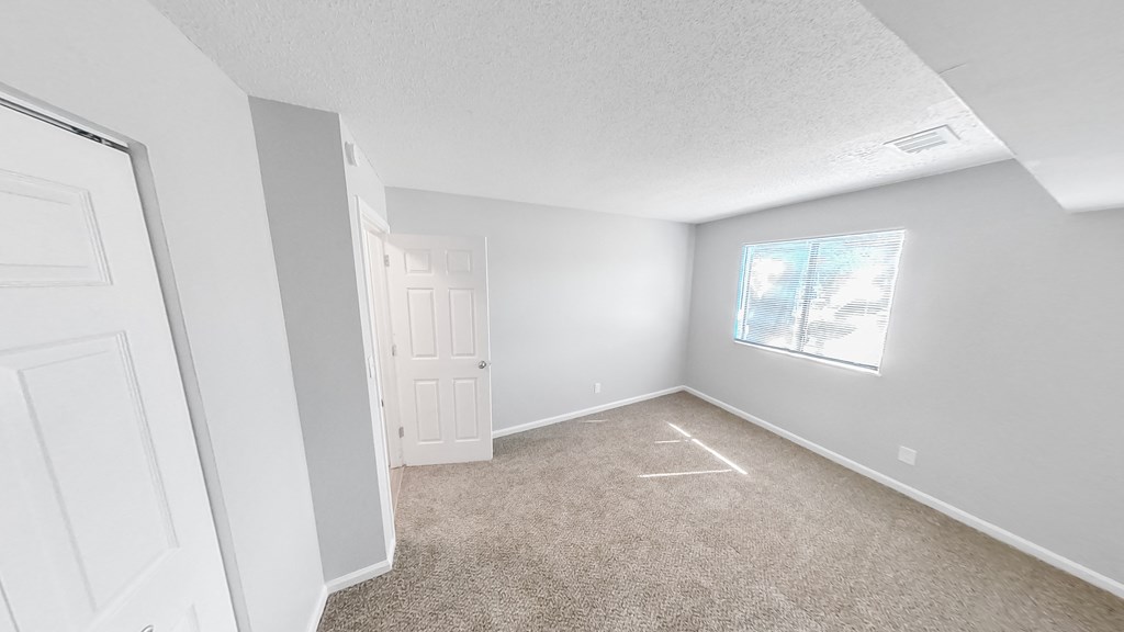 an empty room with carpet and a window
