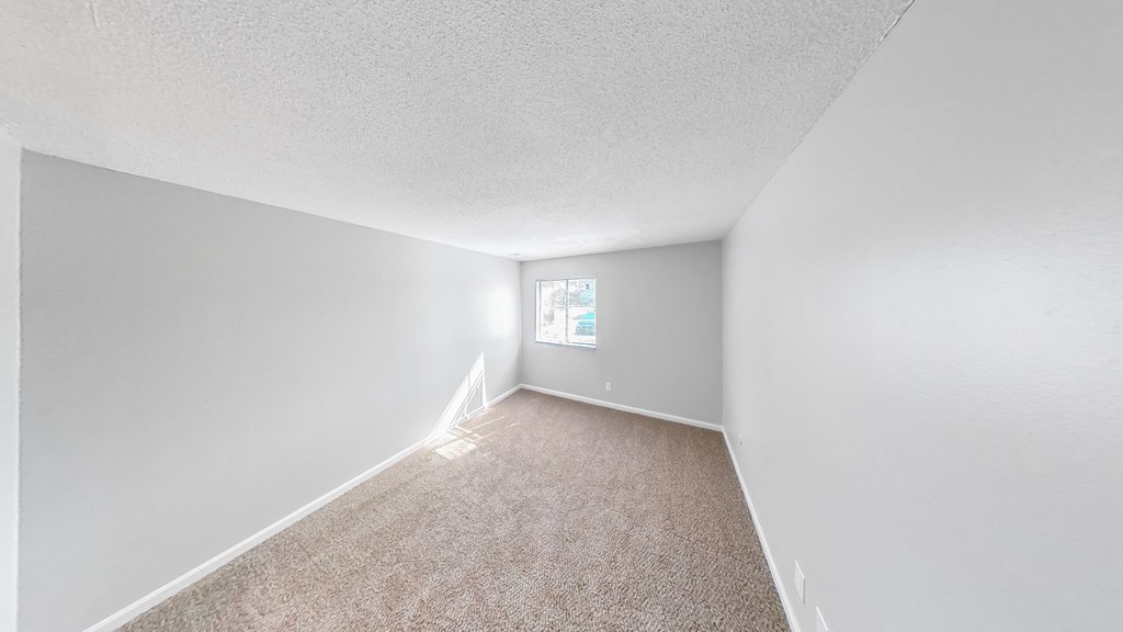 an empty room with carpet and a window