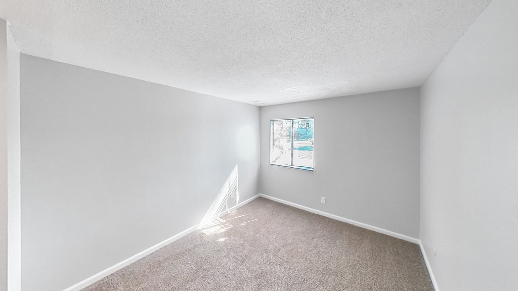 an empty room with white walls and a window