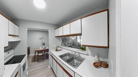 a kitchen with white counter tops and a stainless steel sink