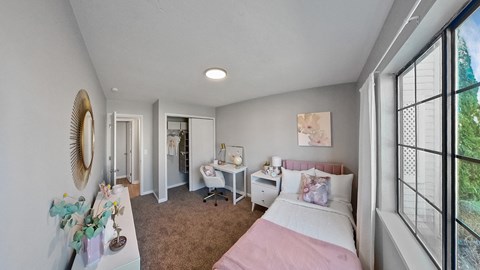 a bedroom with a bed and a desk and a window