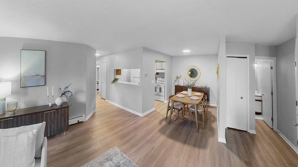 a living room and dining room with white walls and wood floors at The Element @ St Andrews, Indiana, 46545