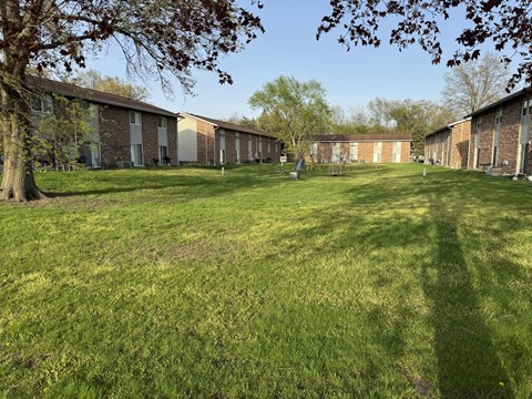 A grassy field with a building in the background.