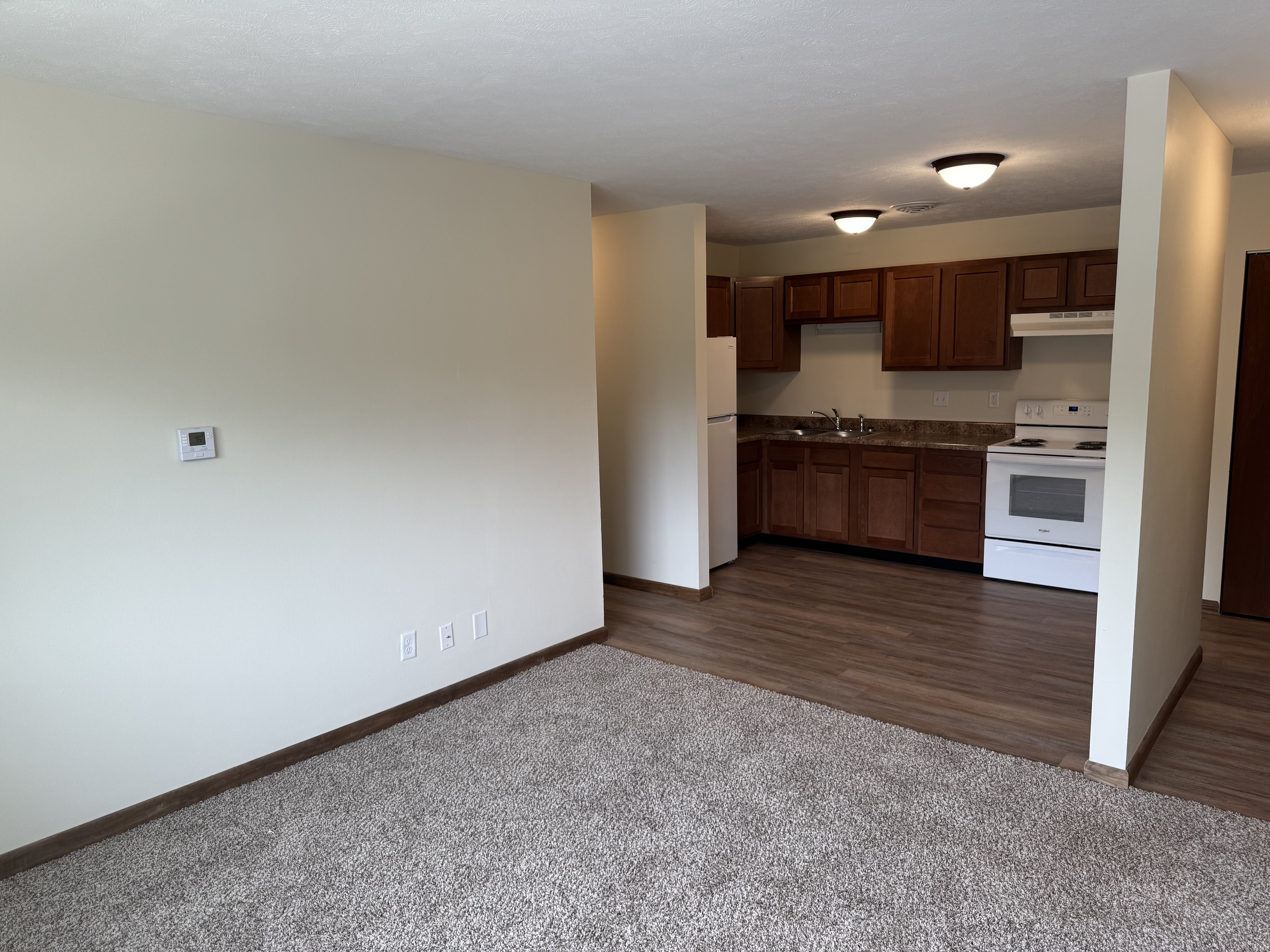 A kitchen area with a white oven and wooden cabinets.