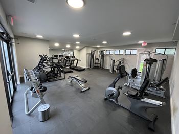 A gym with a variety of equipment including treadmills, weights, and exercise machines.