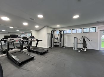 A gym with treadmills, elliptical machines, and a rowing machine.