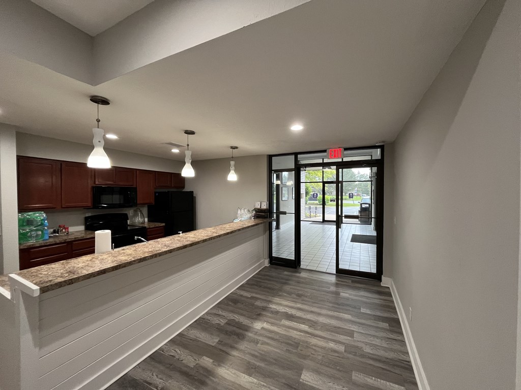A kitchen with a granite countertop and a view of the outside.