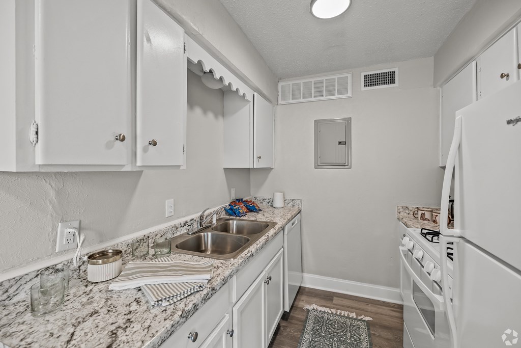 A kitchen with white cabinets and appliances. at La Bella Apartments, Fort Worth, TX