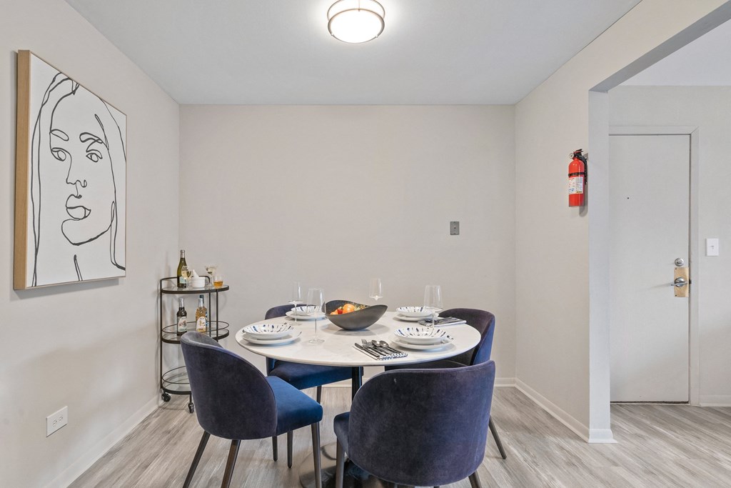 a dining room with a table and chairs and a painting on the wall