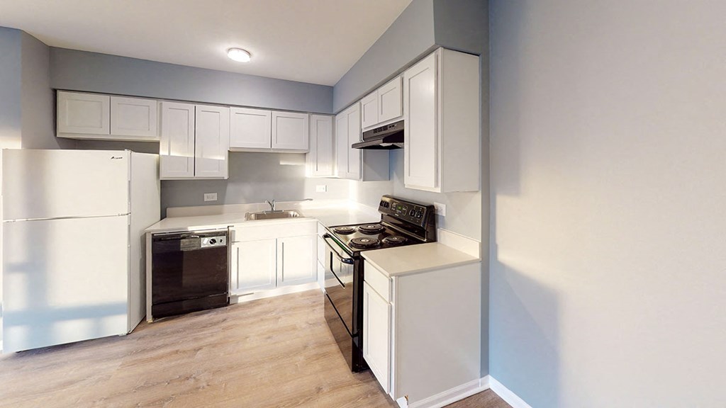 a kitchen with white cabinets and a stove and a refrigerator