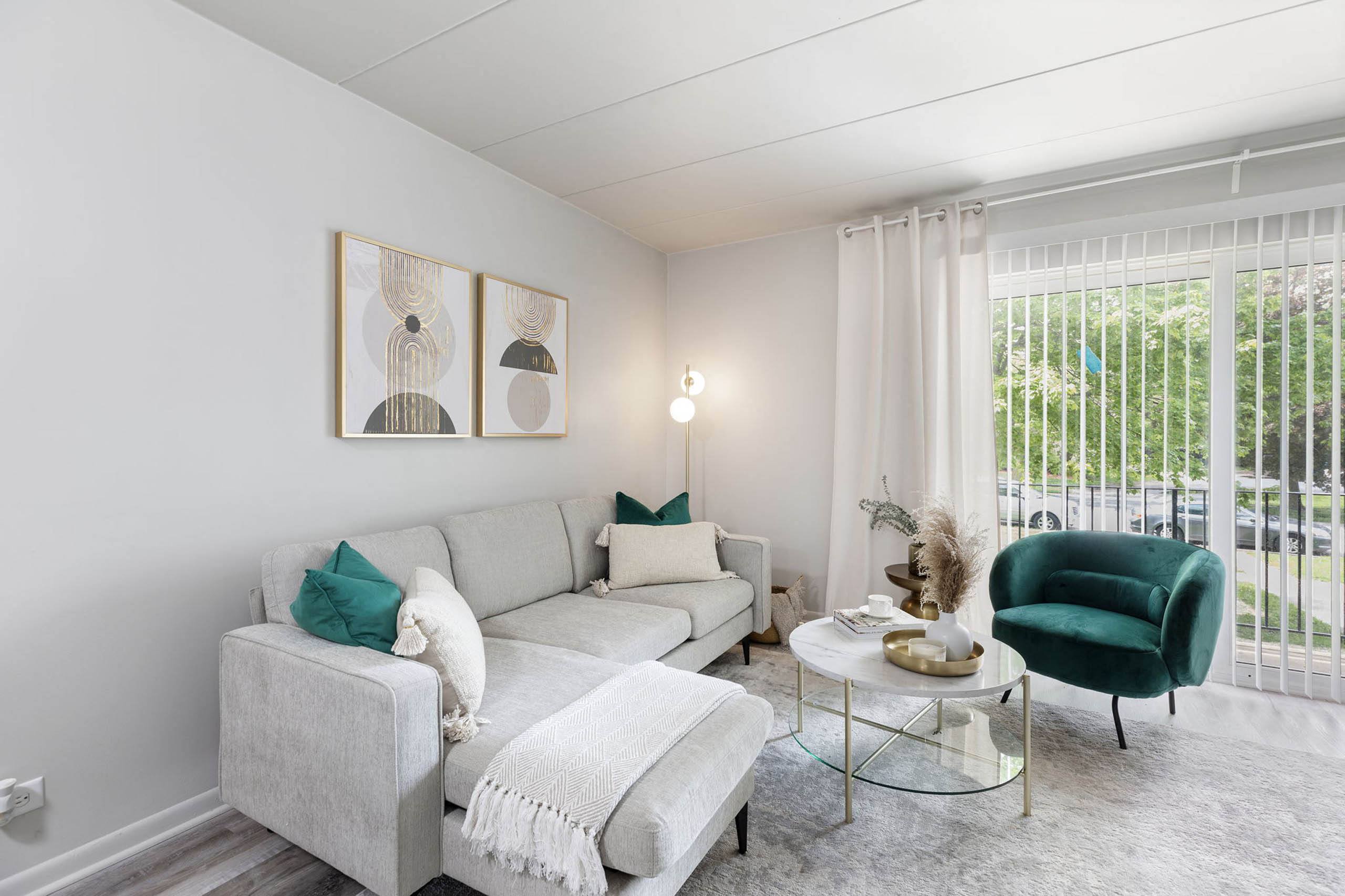 a living room with a white couch and a green chair
