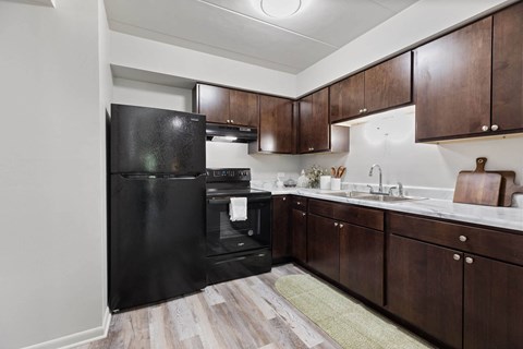 a kitchen with black appliances and wooden cabinets