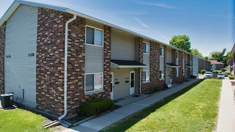 A row of brick apartment buildings with garage doors.