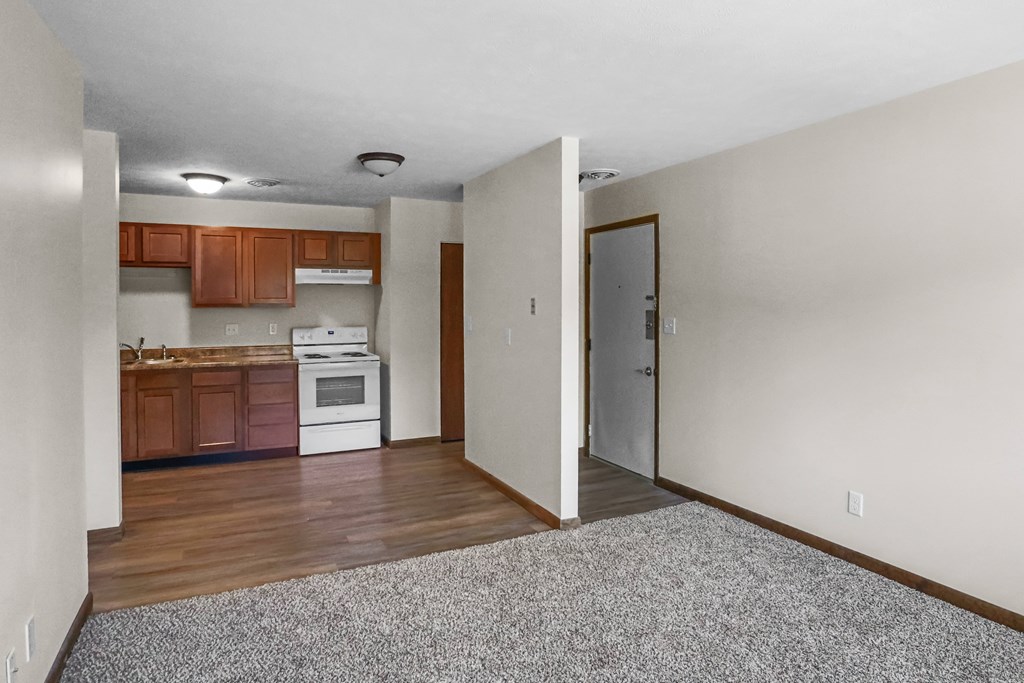 A kitchen with white appliances and wooden cabinets.