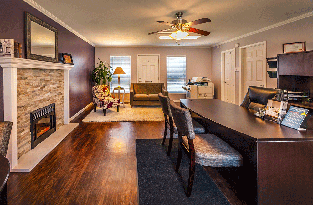 a living room with a fireplace and a table and chairs