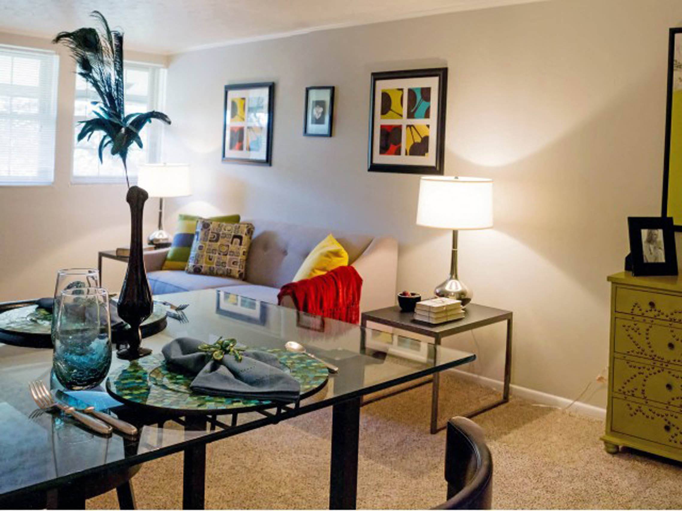 a living room with a glass table and a couch