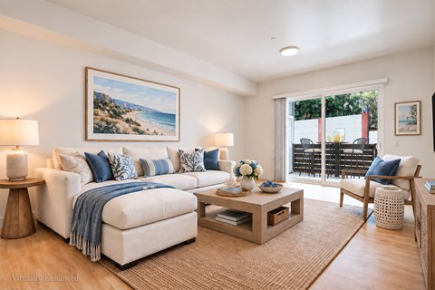 A living room with a white couch, a coffee table, and a painting on the wall.