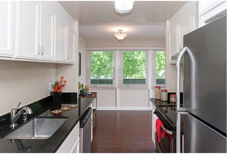 A kitchen with black countertops and white cabinets.