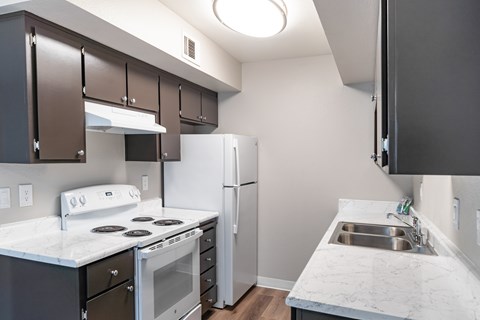 A kitchen with a white counter top and a white stove top oven.