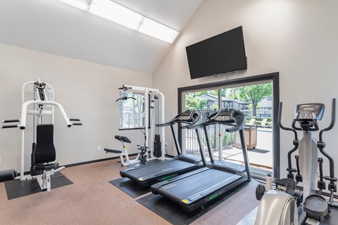 Fitness center with cardio equipment and strength machines at Clayton Creek Apartments, Concord, 94521