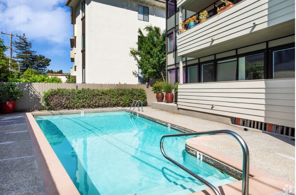 A small pool with a metal ladder sits in front of a building.
