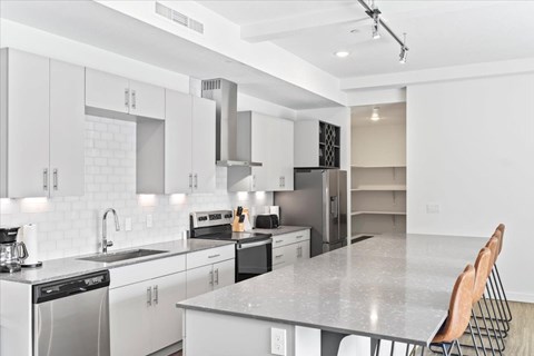 A modern kitchen with white cabinets and appliances. at Paperbox Lofts, Utah, 84101