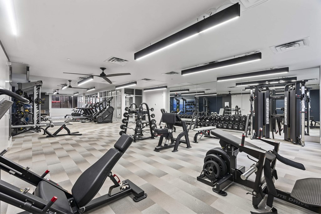 A spacious gym with a variety of equipment including treadmills, weights, and exercise machines. at Brickside Heights, Utah, 84106