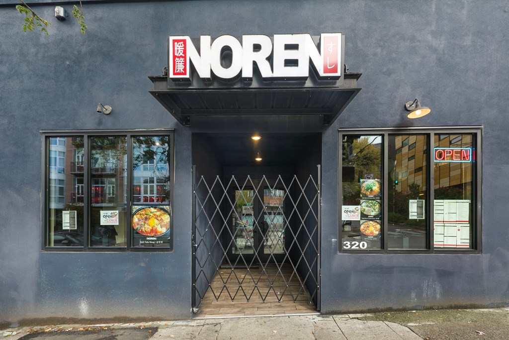 The entrance to a Noren store with a glass door and window.