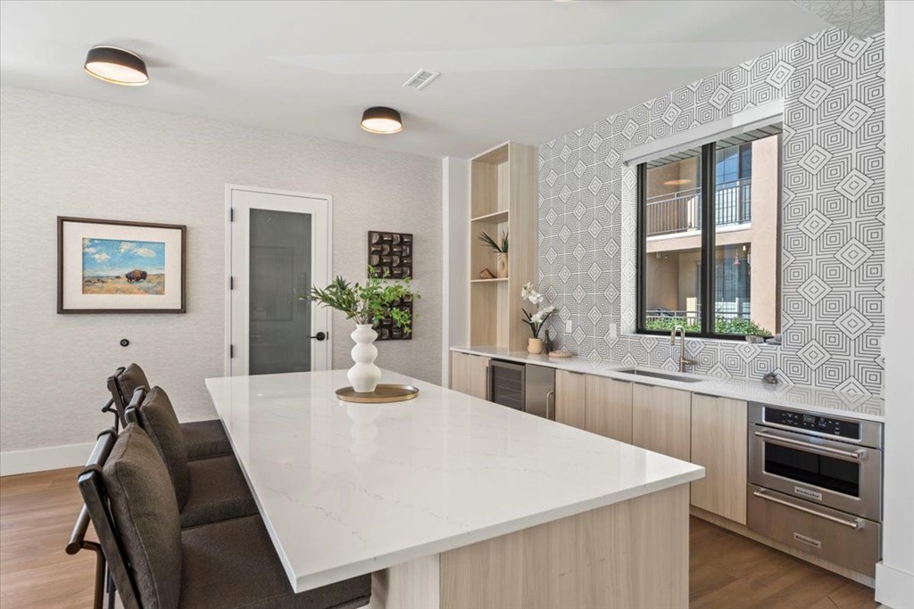 A modern kitchen with a large island and a dining table. at Siena Villas Apartments, Orem, UT