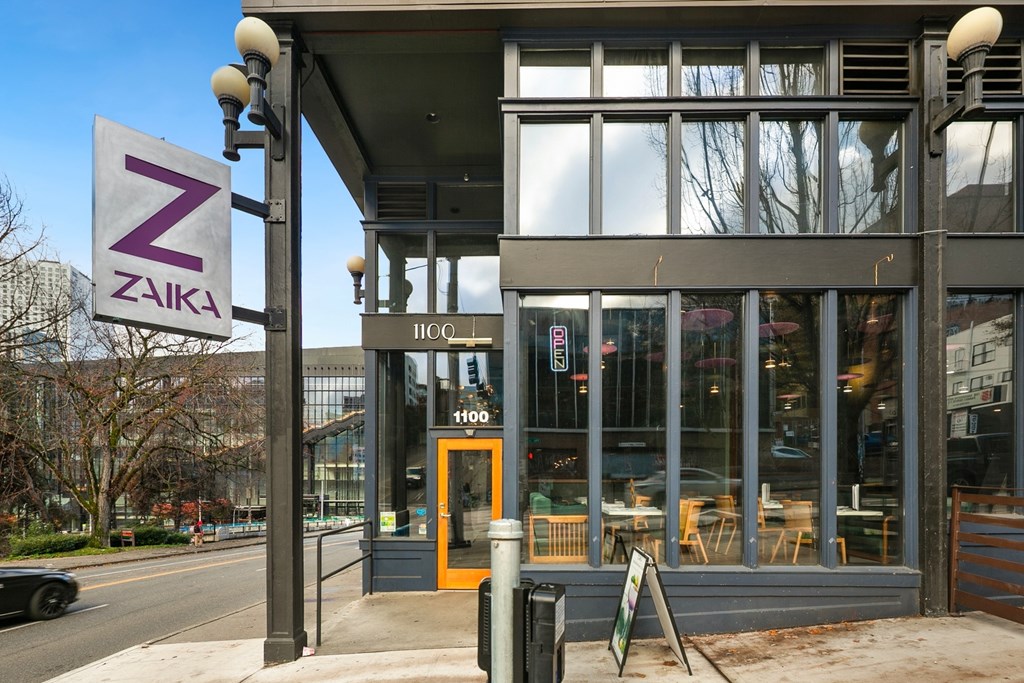 Zaika restaurant with a signboard and a car parked in front.