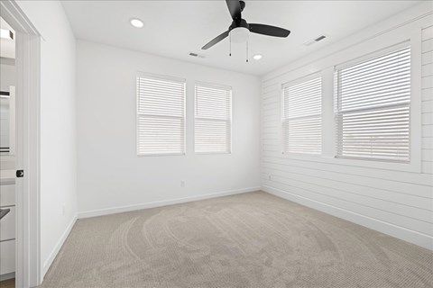 A room with a ceiling fan and two windows.at Alante Homes at Spring Run, Caldwell Idaho
